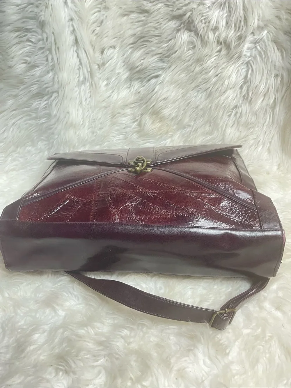 M.C textured leather patchwork like stitched accent burgundy leather bag .